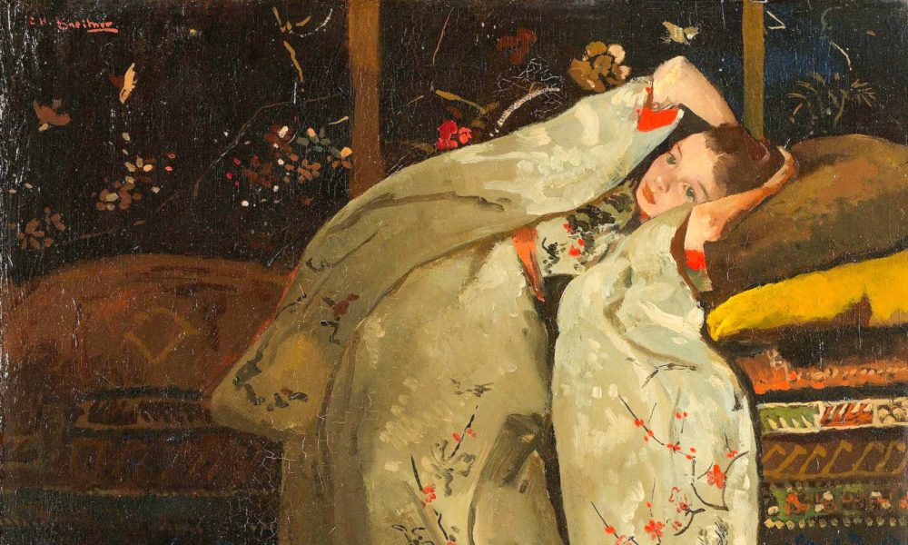 A woman in a kimono posing on a bed. The kimono is cream with red flowers.